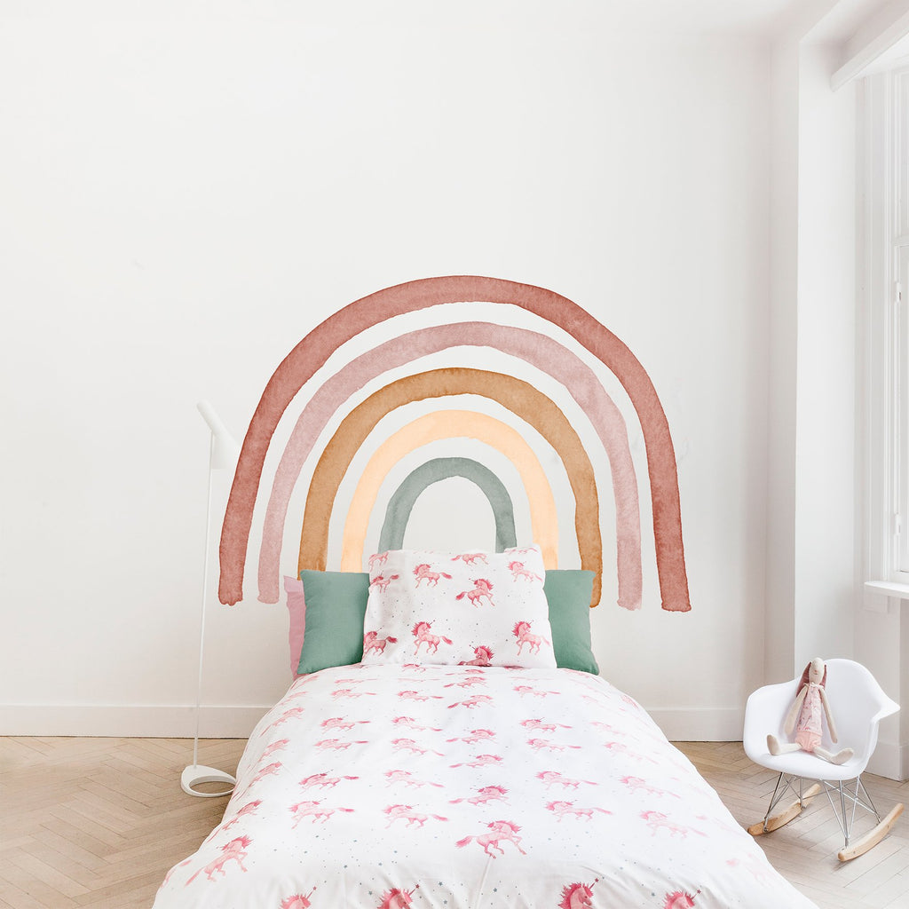 Bett mit Einhorn Bettwäsche mit einem schönen pastellfarbenen Regenbogen Wandsticker in naturtönen.